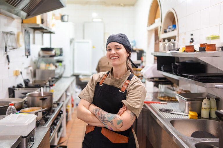 Portrait of proud and modern female chef at restaurant standing arms crossed