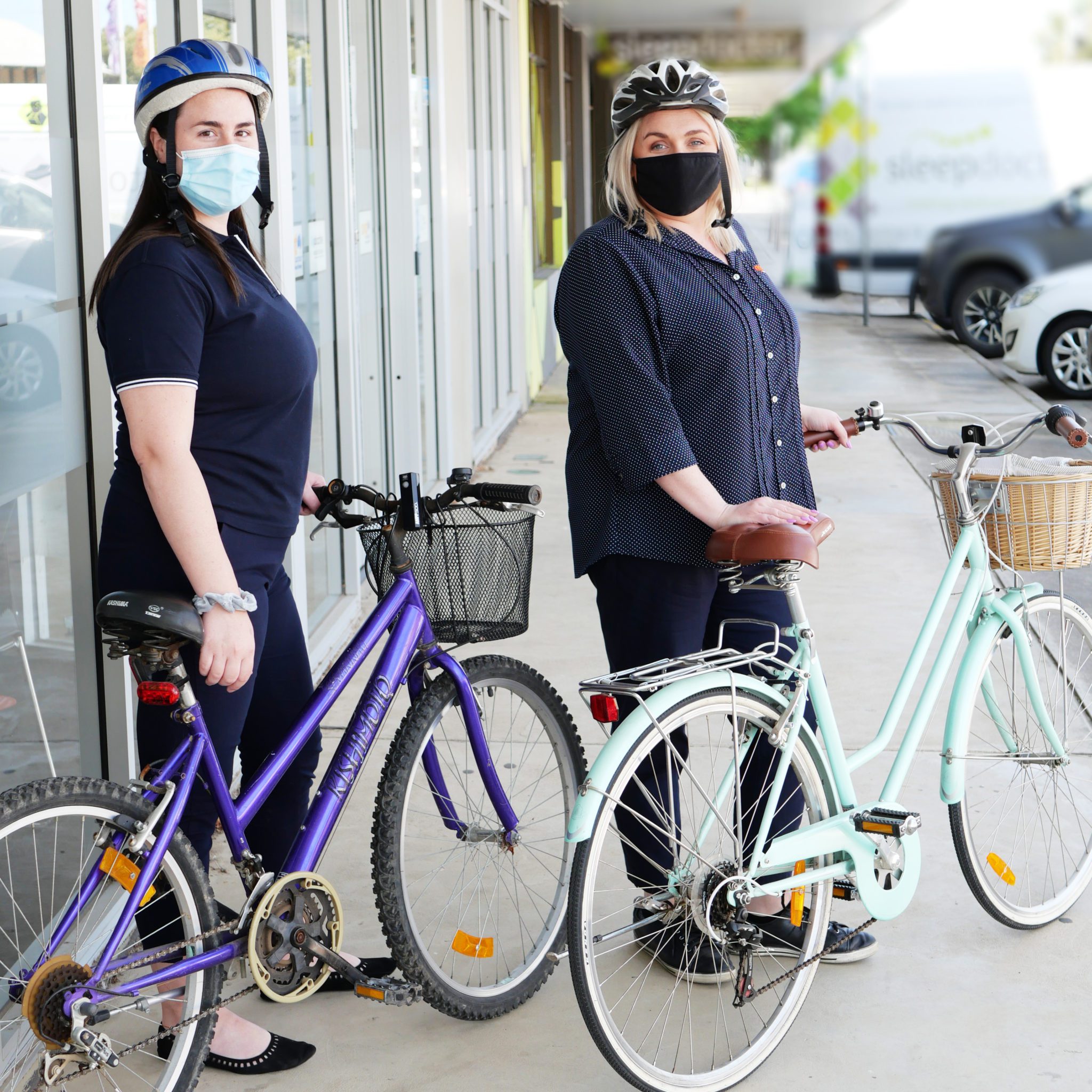 2 ladies besides 2 bicycles