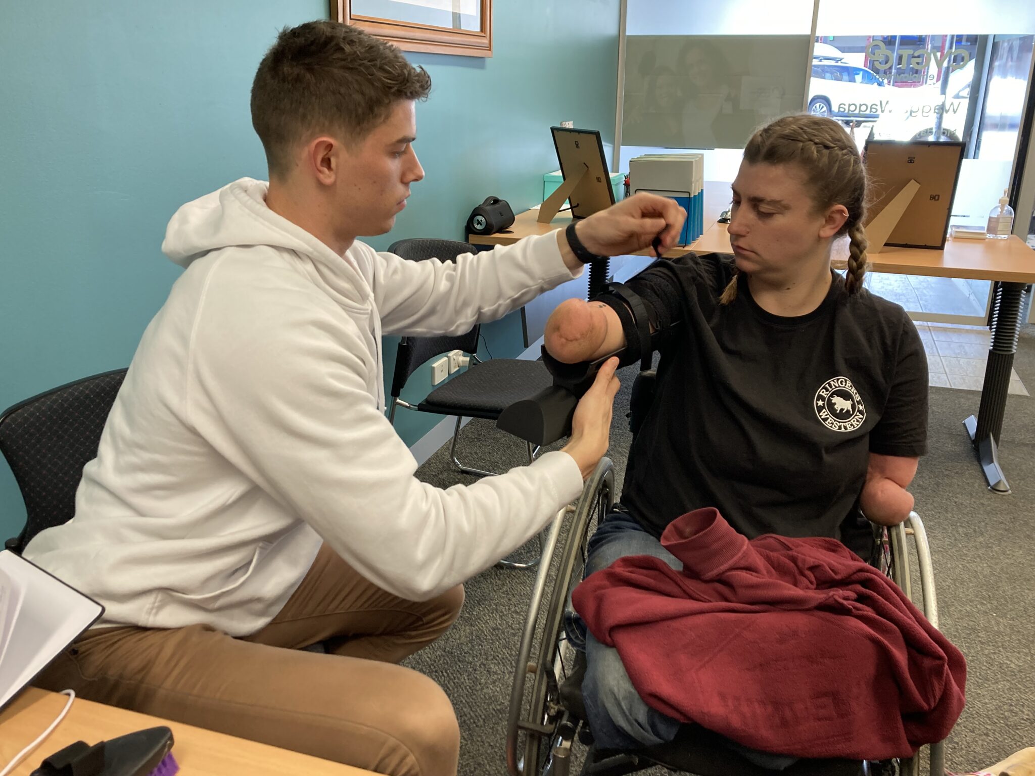 Charles from University of Wollongong fits Grace's new assistive grooming device.