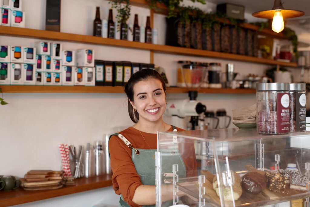 female barista smiling whilst working inside coffee shop austockphoto 000105105