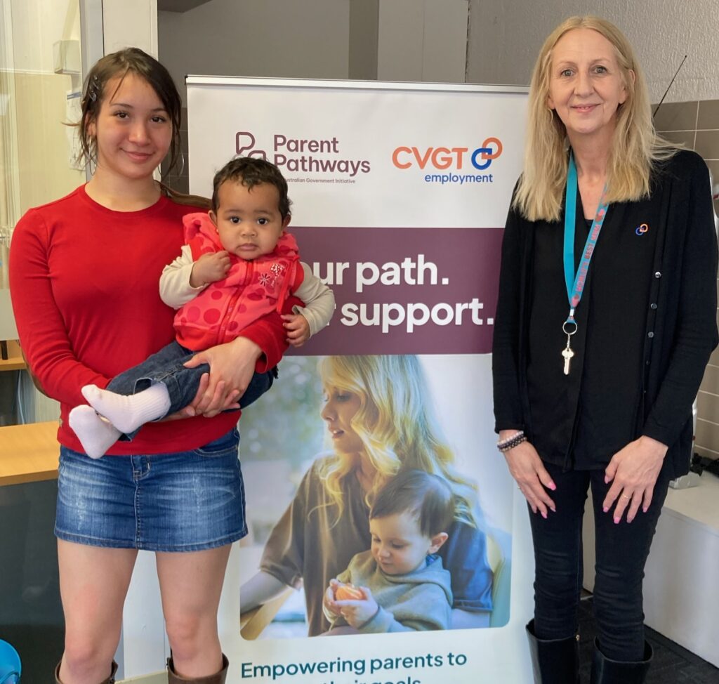 Parent Pathways participant and mother with mentor and child standing in front of CVGT Employment pull up banner.