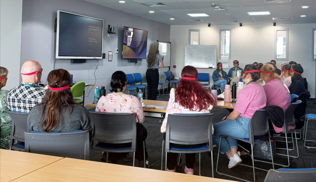 Kaye Jones, Employment Service Lead at Guide Dogs Victoria, leads a guided blindfold activity at Each
